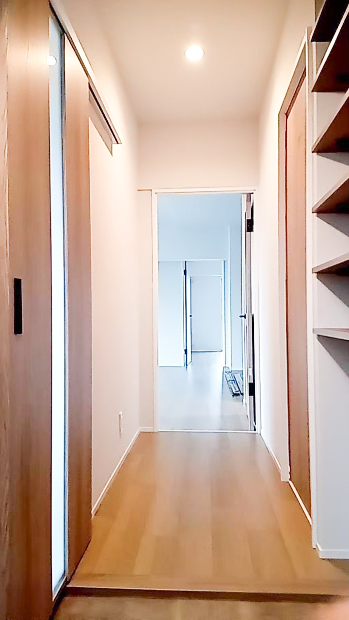 明石市のマンションリノベーション事例|木製建具とオープン棚が続く玄関からの廊下|TEAM-R
