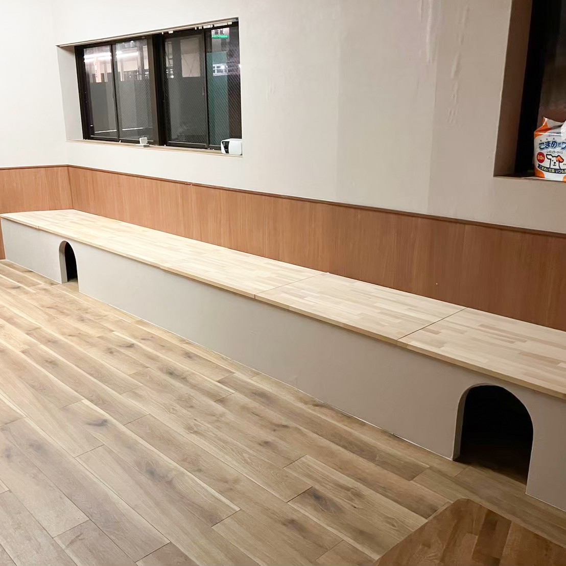 高槻市の猫カフェ造作ベンチ事例。集成材の天板と、猫が通り抜けられるアーチ型トンネル付きの造作ベンチ|TEAM-R