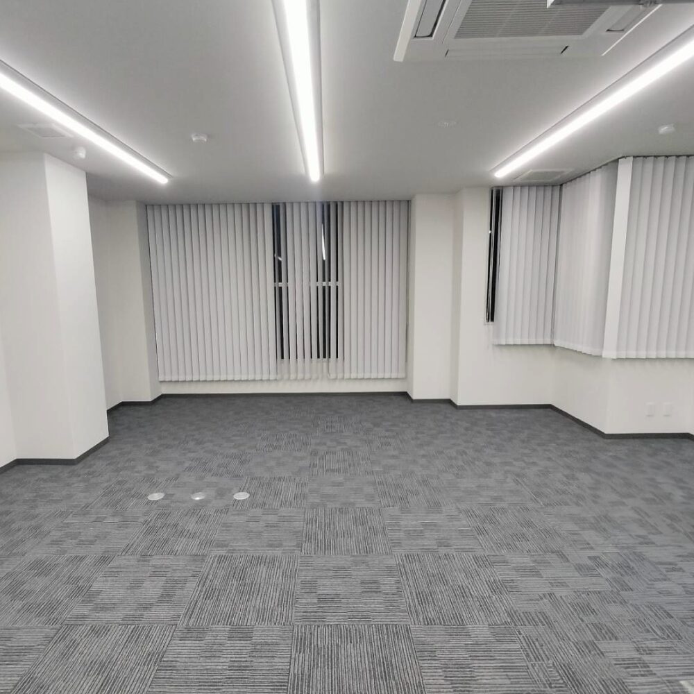 大阪市中央区の店舗リノベーション事例(ビフォー)。グレーのタイルカーペットが敷かれた、改装前のオフィス空間|TEAM-R