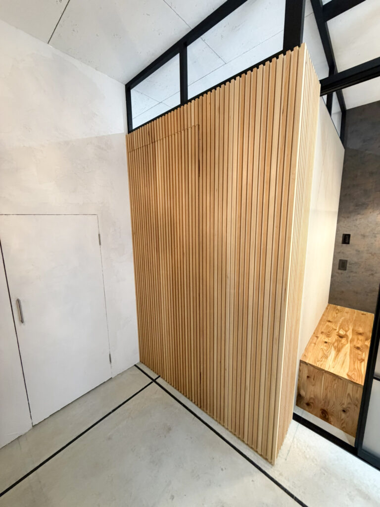 堺市西区の店舗リノベーション事例 木の縦格子に溶け込む造作の隠し扉(閉じた状態)|TEAM-R