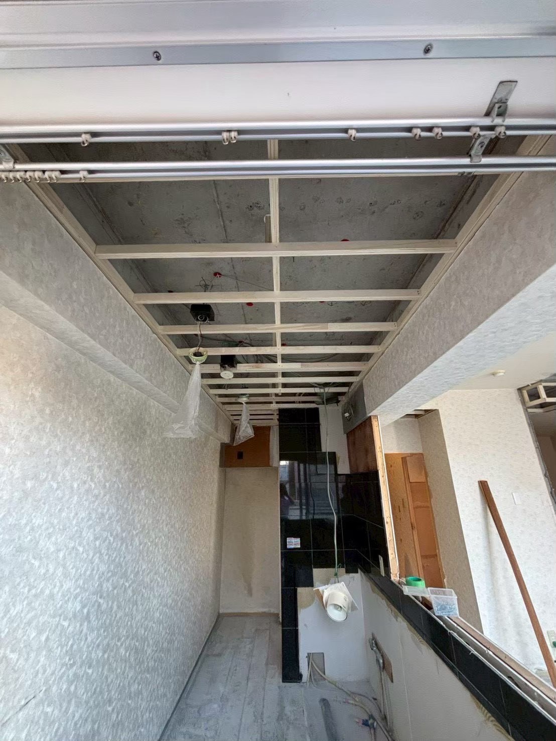 大阪市淀川区のマンションリノベーション事例（ビフォー）｜天井を解体して下地を組んだ既存キッチン、黒タイルのカウンター｜水まわりリフォーム
