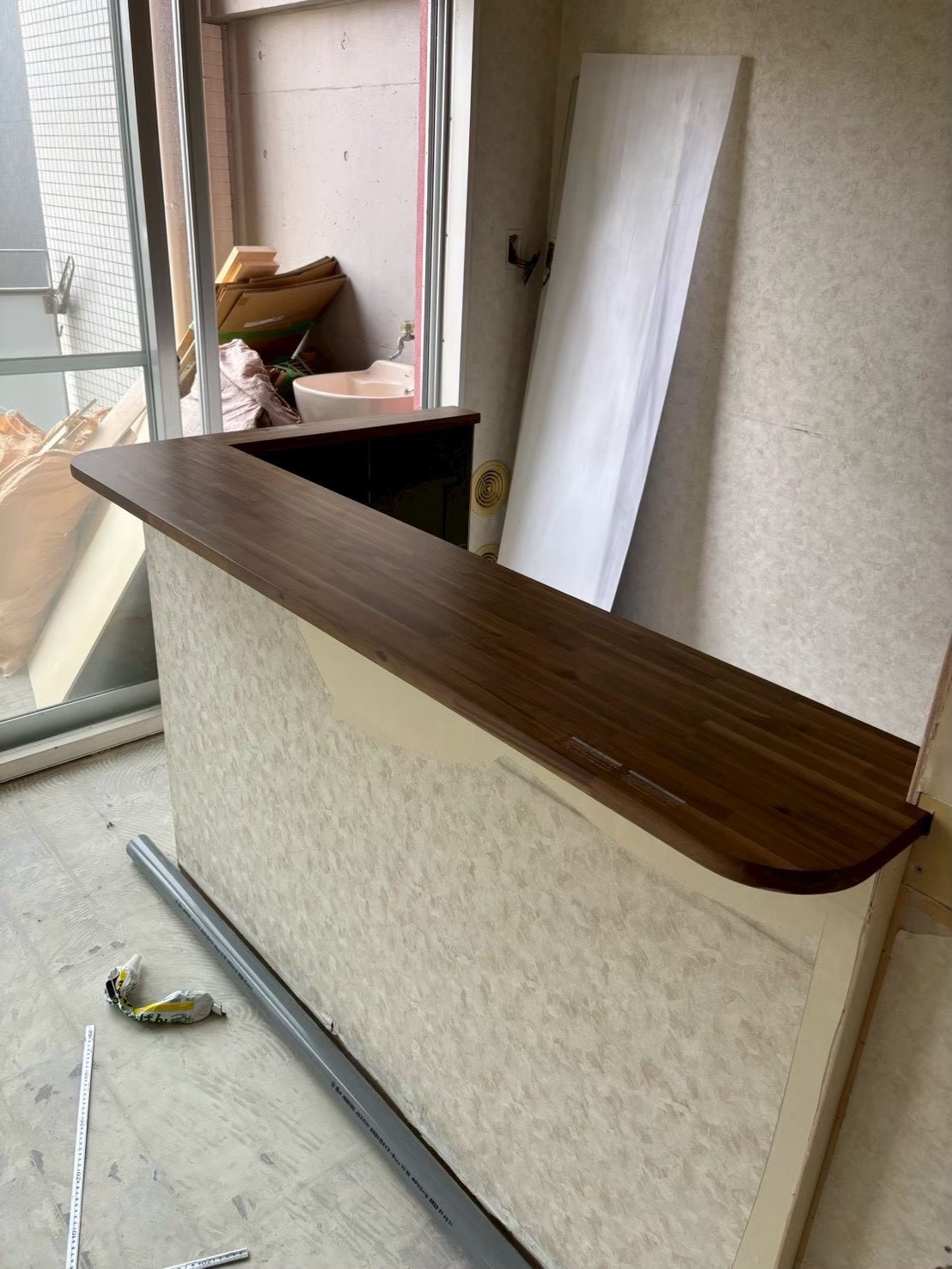 大阪市淀川区のマンションリノベーション事例（施工中）｜対面カウンターに取り付けた、丸みのある集成材の造作天板｜造作工事