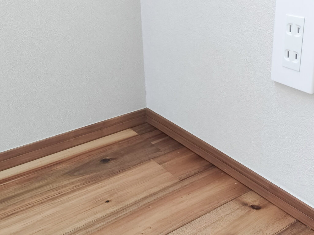 入隅にきれいに納まった木製巾木の寄り|巾木の納まりの説明イメージ