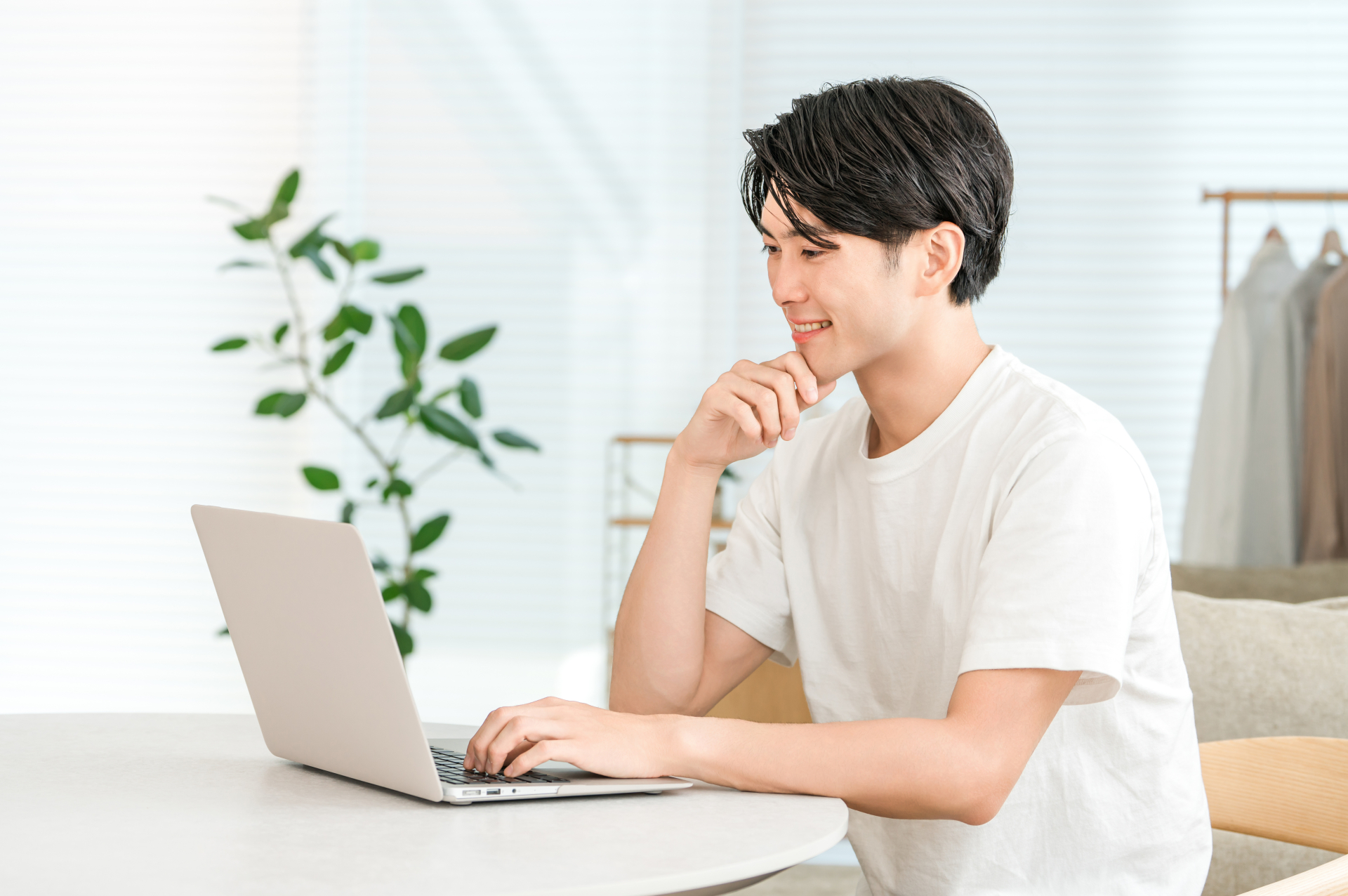 開業に向けてPCで調べている男性の画像